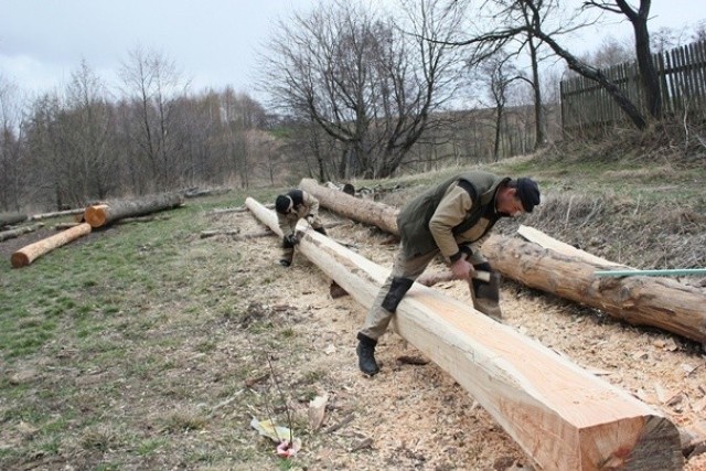 Pracownicy firmy Bonar Marek Danielski i Mariusz Kończak ociosują drewno na krzyż.