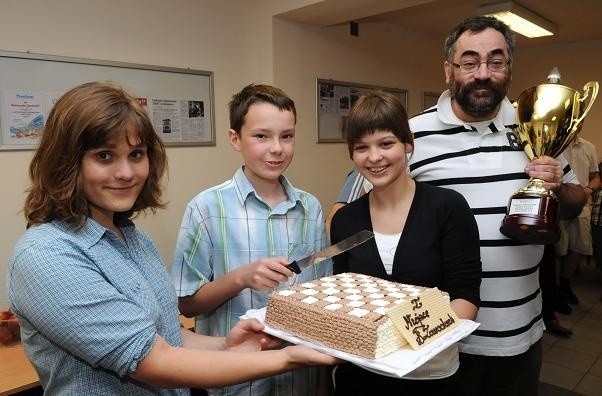 Do uroczystego krojenia tortu zabrali się (od lewej): Maria Demidowicz, Kamil Dragun, Klaudia Wiśniowska i dumnie prezentujący zdobyte w Chotowej puchary trener Aleksander Czerwoński