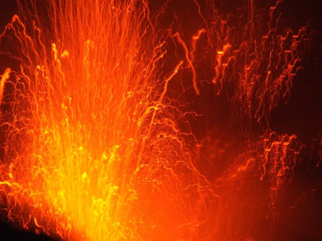 Z czeluści kratery wydobywają się ogromne ilości gorącej lawy.