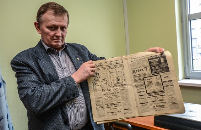Dr Franciszek Bromberek, rzecznik rektora UTP prezentuje gazetę, która znajdowała się w kapsule czasu