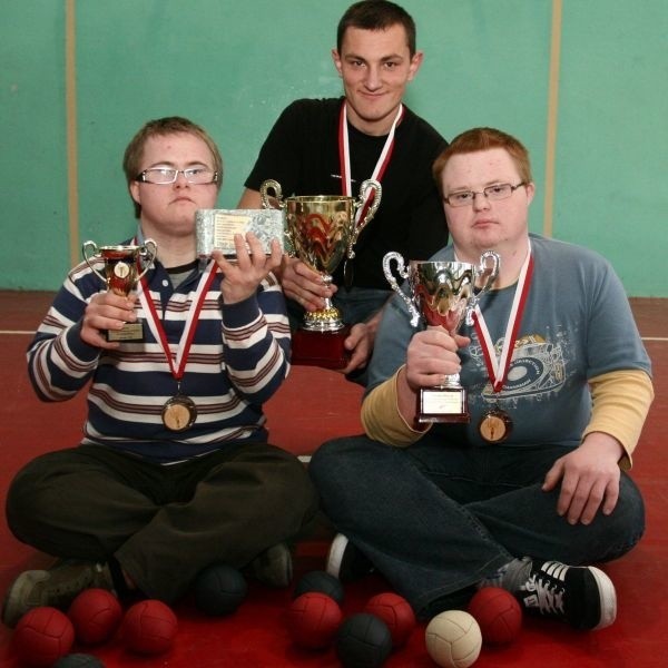 Mateusz Jaśkiewicz, Mikołaj Żyła i Tomek Zawisza z dumą prezentują zdobyte w Zamościu medale i puchary oraz kostkę z posklejanych pieniędzy.