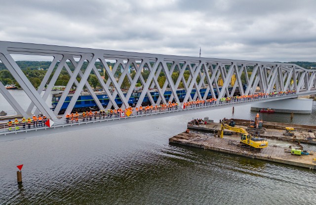 Prace przy budowie nowej przeprawy rozpoczęły się z końcem 2021 roku, w styczniu 2022 roku wykonawca zaczął pracować w nurcie Odry Wschodniej. Powstający most ma trzy przęsła, najdłuższe z nich mierzy 114 metrów. Całkowita długość mostu to 306 metrów. Poszczególne części mostu powstały na południu Polski, wykonał je Mostostal Kraków. Do Szczecina dotarły drogą lądową. Wykonawcą prac jest Budimex SA