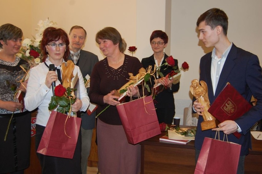 Od prawej z kwiatami stoją laureaci:  Adam Zubrzycki z...