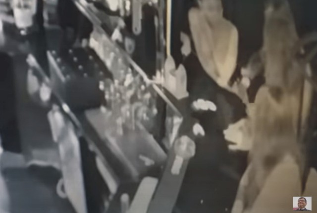 Kadr z film udostępnionego przez Zbigniewa Stonogę na YouTubie. Widać na nim, jak funkcjonariusz SOP przy barze wyciąga pistolet.