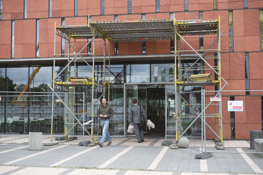 Wokół budynku biblioteki w niektórych miejscach jest płot, w...