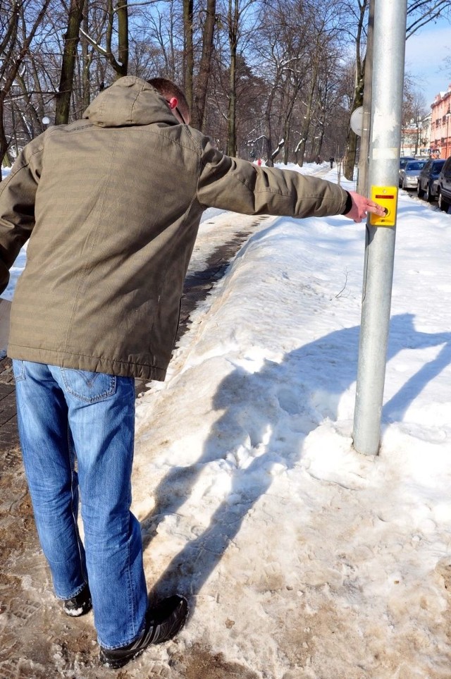 Przechodnie na radomskich ulicach muszą często wykazywać się sprytem, żeby wcisnąć przycisk, który znajduje się na słupku sygnalizatora, obsypanego dookoła śniegiem.