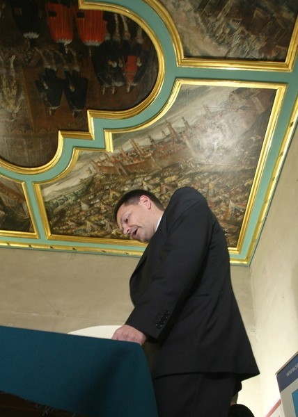 Dyrektor muzeum Robert Kotowski pod  lśniącym złotem i świeżą farbą plafonem w apartamencie senatorskim