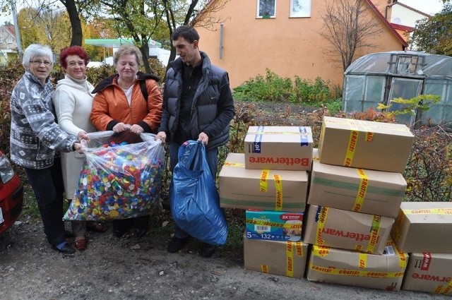 Krzysztof Dymecki z paniami z LKP ładują kolorowe nakrętki, które pomogą jego córce wyjechać na leczenie.