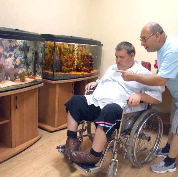 Zbigniew Gregier ze swoim synem Krzysztofem oglądają rybki w akwariach w sali biologicznej.