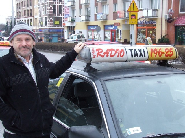 Jerzy Olczak, taksówkarz z 34-letnim stażem, od początku związany z STS Radio Taxi, pokazuje, jak powinno wyglądać prawidłowe logo sieci, w której pracuje.