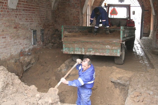 Robotnicy Zakładu Wodociagów i Kanalizacji zasypują głęboką dziurę pod Bramką Grudziądzką