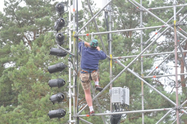 Ekipa z firmy Trias uwija się przy montowaniu oświetlenia dużej sceny Przystanku Woodstock 2014