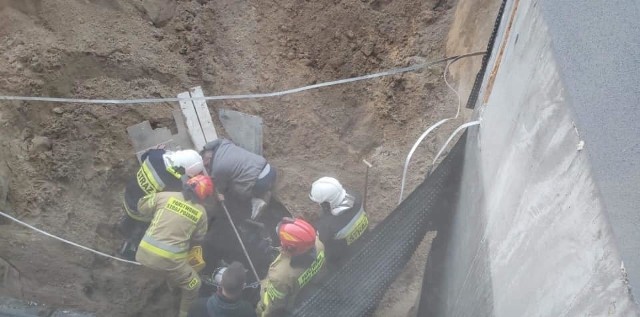 Do bardzo groźnego zdarzenia doszło dzisiaj (18.11) na placu budowy przy ul. Kujawskiej w Solcu Kujawskim. Podczas prac jeden z pracowników został przysypany.Mężczyzna uwięziony był w sześciometrowym wykopie, jednak jego głowa znajdowała się na powierzchni.Strażacy, którzy pojawili się na miejscu założyli mężczyźnie aparat ochrony układu oddechowego. W następnej kolejności przystąpili do zabezpieczenia wykopu oraz koparki, która znajdowała się bezpośrednio nad osobą poszkodowaną.Po upewnieniu się, że zagrożenie zostało zminimalizowane zaczęto wydobywanie mężczyzny. Strażacy wycięli część rury kanalizacyjnej, do której przyciśnięty był poszkodowany. Cała akcja ratunkowa trwała około 1,5 godziny.Na szczęście przysypanemu pracownikowi nie stało się nic poważnego. Trafił do szpitala z objawami hipotermii. Jego życiu nie zagraża niebezpieczeństwo. WIĘCEJ ZDJĘĆ Z AKCJI NA KOLEJNYCH STRONACH >>>>>Zobacz także: Kobiety poszukiwane przez policję z regionu. Oto przestępczynie z woj. kujawsko-pomorskiego [ZDJĘCIA]