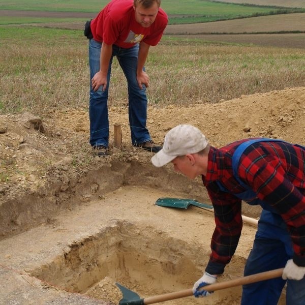 Archeolog Kamil Kaptur dogląda zdejmowania wierzchnich warstw ziemi na terenie badań w Krzczonowicach.