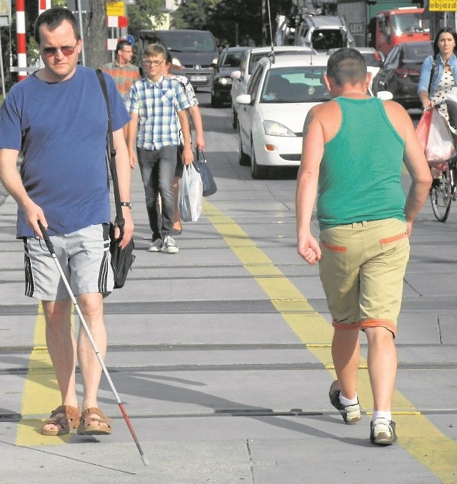 Leszek Sawicki pokazuje, że tymczasowe przejście przez tory nie uwzględnia potrzeb osób niewidomych i niepełnosprawnych