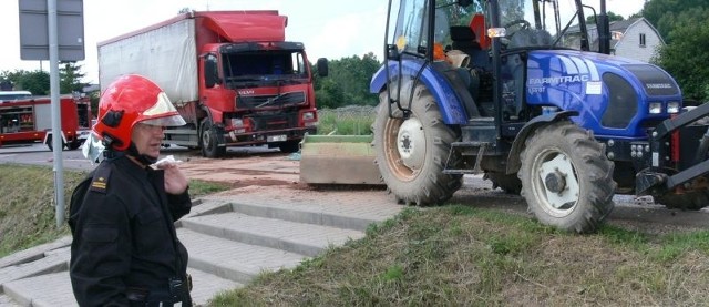 Młodszy brygadier Waldemar Madej pokazuje skutek zderzenia &#8211; rozbity przód Tira i uszkodzony nowy traktor oczyszczający jezdnię. 