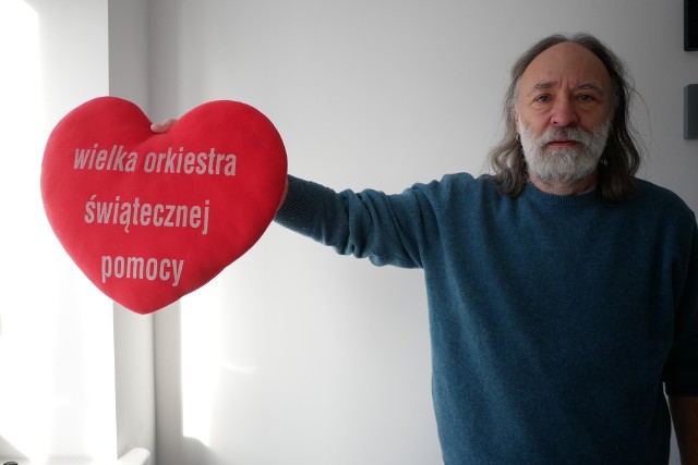 Krzysztof Ranus prezentuje poduszkę w kształcie serduszka Wielkiej Orkiestry Świątecznej Pomocy