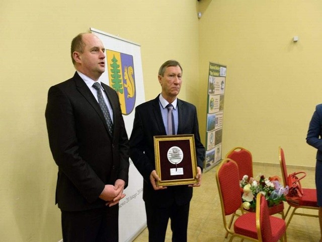 Wójt Michał Skałecki (z prawej) z nagrodą  za trzydzieści lat pracy. Gratulacje składa marszałek Piotr Całbecki.