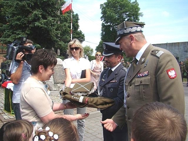 Gen. Andrzej Przekwas wspólnie z płk. Władysławem Leśnikowskim przekazują Barbarze Kwiatkowskiej replikę munduru generalskiego.