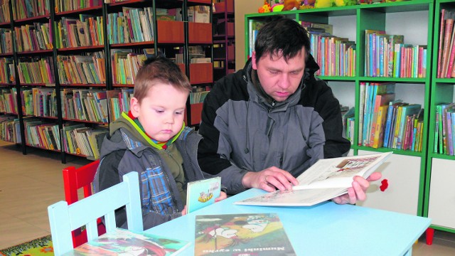 Dzieciaki  przychodzą do biblioteki z rodzicami, którzy pomagają im wybrać książki. 