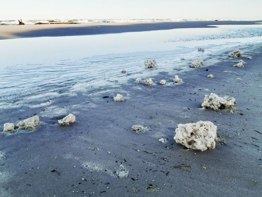 Trwa uprzątanie plaży w Łebie z parafiny. Podobna sytuacja jest w kilku innych miejscach na wybrzeżu