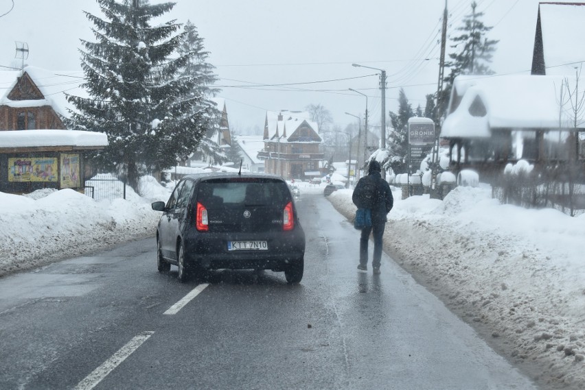 Z uwagi na zasypane śniegiem chodniki, piesi idą jezdnią