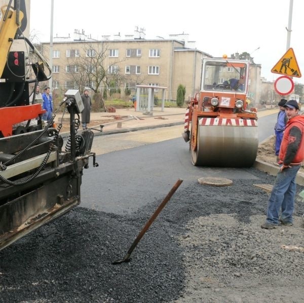 Układanie warstwy wiążącej asfaltu na ulicy Popiełuszki.