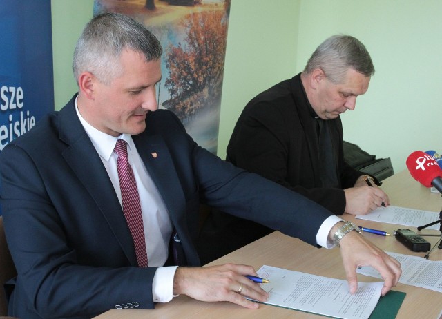 Umowę podpisują wicemarszałek Mazowsza Rafał Rajkowski i ks. Roman Adamczyk z Radomia.
