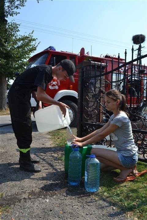 Strażacy z narażeniem zdrowia wożą wodę ludziom w...