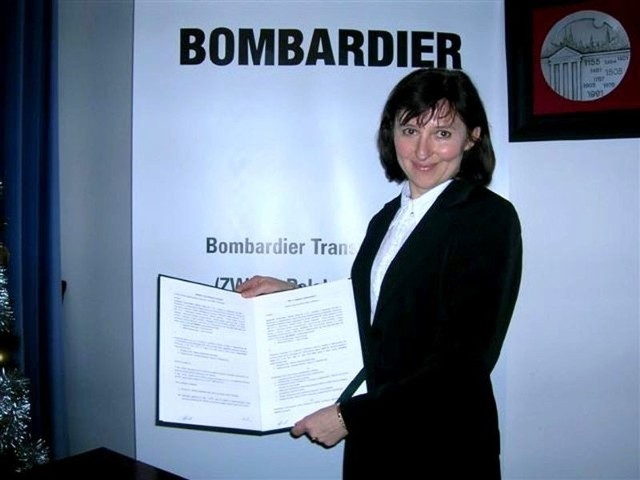 Elżbieta Szychta, dziekan Wydziału Transportu i Elektrotechniki Politechniki Radomskiej pokazuje umowę, podpisaną z firmą Bombardier Transportation.