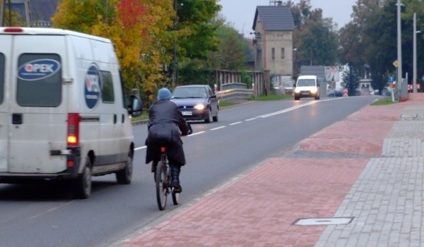 Rowerzyści jadąc po wąskiej ulicy ryzykują życiem.