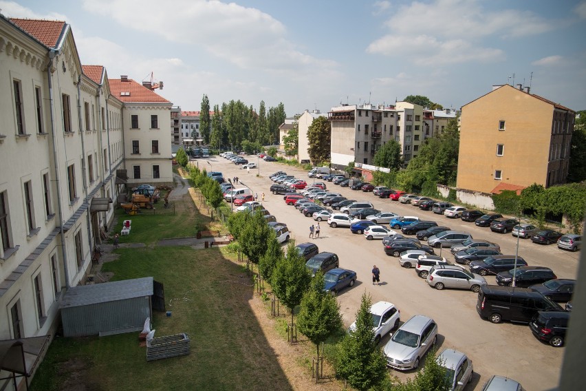 Na parkingu ma być park. W oddali drzewa przy ul....