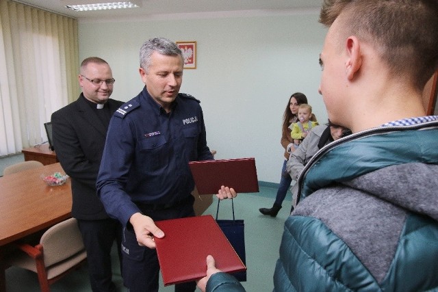 Komendant miejski kieleckiej policji Artur Bielecki dziękuje jednemu z nastolatków, którzy przyszli z pomocą kielczance