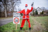 Przy drodze w Mościcach stanęła kukła Świętego Mikołaja. Postać w czerwonym stroju prosi kierowców, aby zwolnili [ZDJĘCIA]