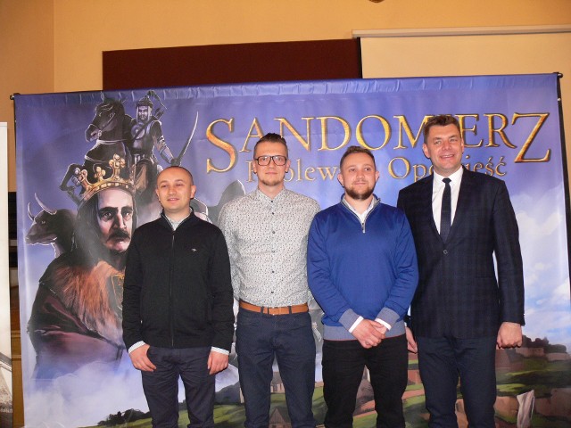 Od lewej: Mariusz Bańkowski, Adam Zwierzyk, Grzegorz Bańkowski oraz Marcin Marzec burmistrz Sandomierza na tle plakatu promującego nowy film o Sandomierzu.