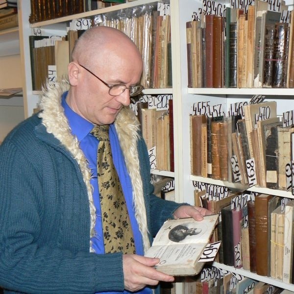 Andrzej Matzger przegląda przeznaczone na aukcję druki z oznaczonymi numerami katalogowymi.