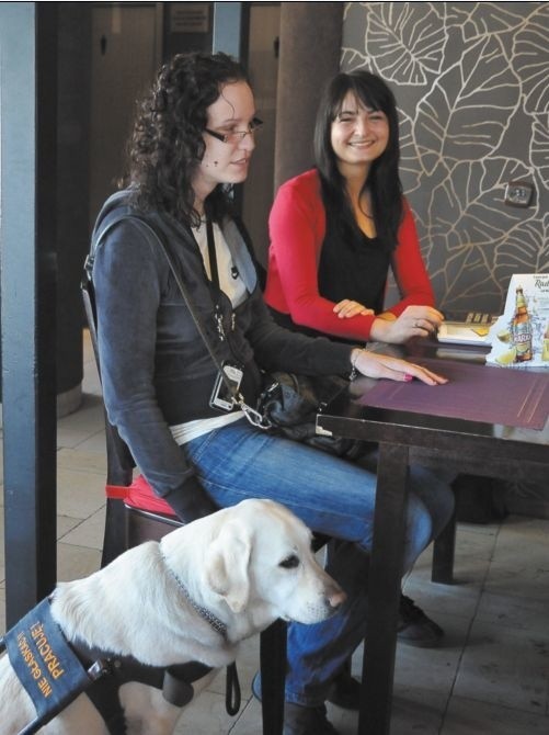 Elena Świątkowska i Katarzyna Tomasiak (z psem), tyflospecjalistki Fundacji Szansa dla Niewidomych, podczas wizyty w Pizzerii Paradiso
