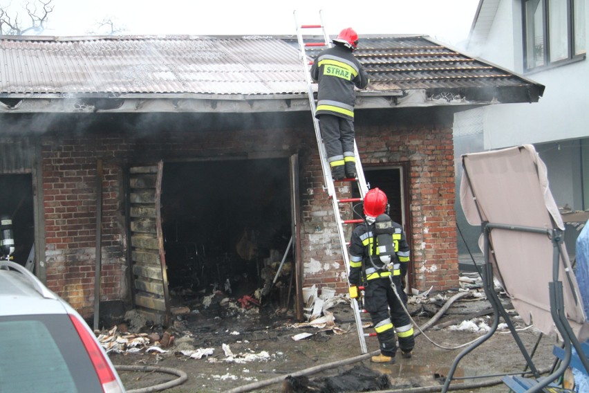 Pożar budynku gospodarczego w Tarnobrzegu przy ulicy Stanisława Orła. Załoga pogotowia udziela pomocy starszej kobiecie z tej posesji