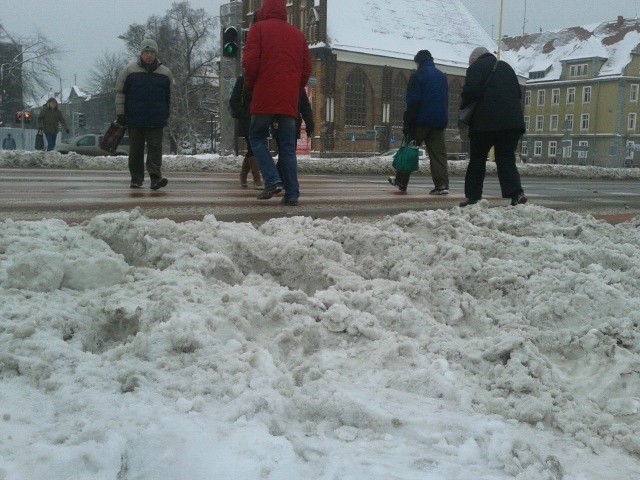 Zima w Szczecinie - służby odśnieżają ulice, ale wciąż wile śniegu zalega na chodnikach, przejściach dla pieszych i na przystankach.
