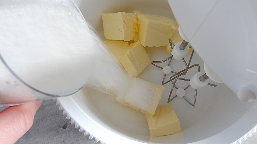 Utrzyj masło z cukrem i wanilią na puszystą, jasną masę.