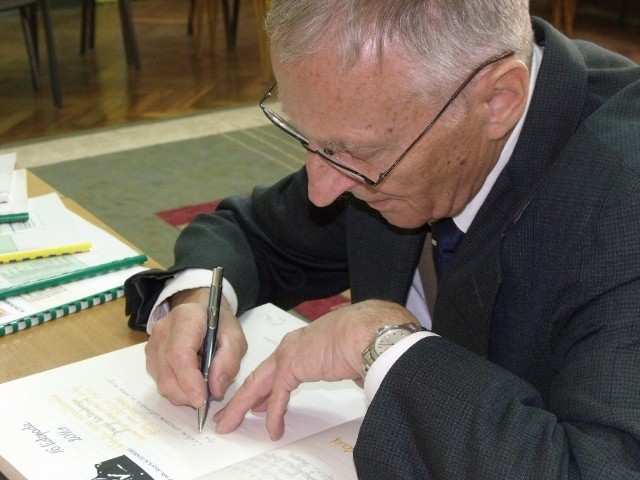 Olgierd Kaltenberg wpisuje się do pamiątkowej księgi Szkoły Podstawowej nr3 w Skarżysku.