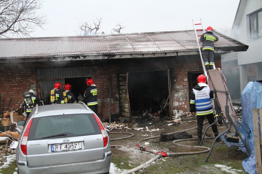 Pożar budynku gospodarczego w Tarnobrzegu przy ulicy Stanisława Orła. Załoga pogotowia udziela pomocy starszej kobiecie z tej posesji
