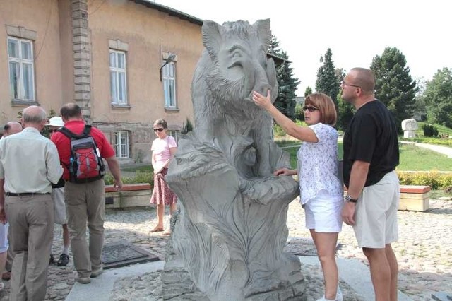 Grupa zwiedzających niewidomych ogląda rzeźbę kieleckiego Dzika.