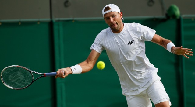 Łukasz Kubot podczas meczu z Milosem Raoniciem na Wimbledonie. Teraz Polak też szykuje się do londyńskiego turnieju, ale w deblu.