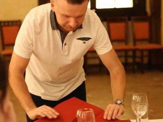 Odpowiednie podawanie do stołu i jego nakrywanie to podstawa pracy kelnera. Młodzież z opatowskiego technikum właśnie tego uczyła w opatowskiej restauracji.  Na zdjęciu: Kelner z opatowskiej restauracji pokazuje młodzieży jak składać serwetę