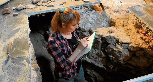 Archeolog Monika Łyczak przy fundamencie filara znalezionym pod posadzką
