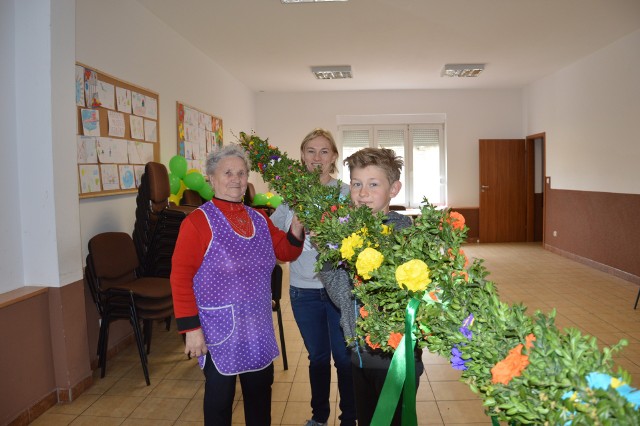 W kościele  filialnym pw św.Jakuba proboscz Czesław Grzelak ogłosił konkurs na najpiękniejszą i największą palmę wielkanocną. Mieszkańcy zrobili takie wielkie palmy, że nie postawią ich w kościele, bo... są za wysokie.Kiedy ksiądz ogłosił konkurs mieszkańcy wioski postanowili połączyć siły i zrobić naprawdę piękne i wielkie palmy. Powstają takie trzy. - Problem jest, ze mają po 7 m i nie postawimy ich w kościele, bo od posadzki do sufitu jest tylko 6,2 m - mówi Anna Mazurek. Palmy naprawdę robią wrażenie. Jedna jest na świetlicy i sięga od drzwi do drugiej połowy pomieszczenia, a druga leży w remizie obok wozów strażackich. Jest dłuższa niż wozy. Robią  ją trzy młode dziewczyny. - Jak widać jeszcze jest nie skończona, ale dzisiaj będzie finał. Będzie miała około 8 metrów wysokości - mówi Natalia Wieczorek. Kiedy zapytaliśmy księdza, co on na to, że palmy są takie wysokie, był bardzo zaskoczony. - Nie spodziewałem się, że aż tak się mieszkańcy przyłożą. 8 metrów? Szok, bardzo duże. No teraz będziemy musieli ocenić. Muszę chyba dla wszystkich nagrody przyszykować - śmieje się ks. Czesław Grzelak. Zenobia Mazurek, synowa Anna i wnuk Mateusz ( zdjęcie) wraz z trzema innymi osobami ( Renata Mazurek, Maryla Działak, Maria Podgórska) zrobili palmę , która ma 7 metrów wysokości. Palma, która jest obok wozów strażackich robią: Natalia Wieczorek, Paulina Wieczorek i Klaudia Mazurek, pomaga Wiktoria Steń.