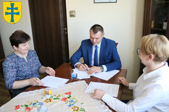 Wójt Karol Burek podpisał umowę w obecności (od lewej) Edyty Walczyk, skarbnik gminy i sekretarz Justyny Niedzieli-Gawlik.