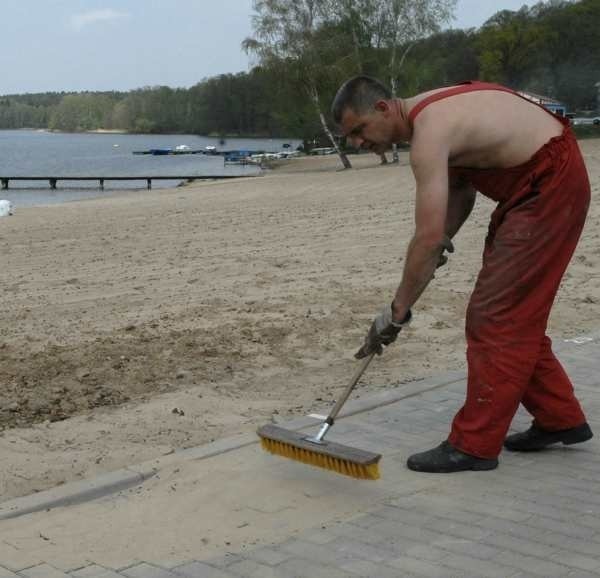 Radosław Hołod ze strzeleckiego PEC-u wykonuje ostatnie prace konserwacyjne na deptaku przy plaży w Długiem