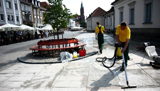Pracownicy firmy Shop-Pracz czyszczą nawierzchnię przy ratuszu